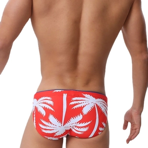 Rear view of men's red swimming briefs featuring white palm tree prints and blue piping