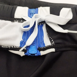 Détail du maillot de bain homme avec fermetures éclair bleues et cordon blanc