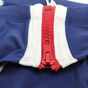 Detail shot of the red resin zipper and white trim on these navy blue swim briefs