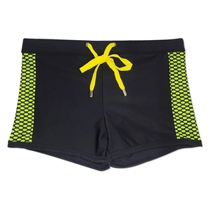 Close-up of black swim trunks featuring bright yellow drawstrings and green side honeycomb patterns