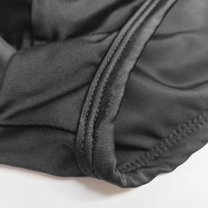 Macro shot of high-quality sewing stitches on black elastic mesh fabric of swimwear