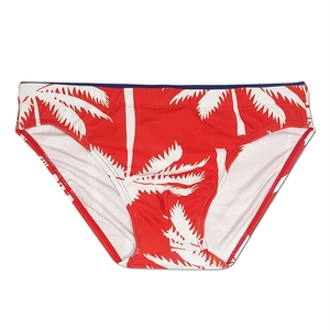 Detail view of red men's swim briefs with white coconut tree prints and blue waistband