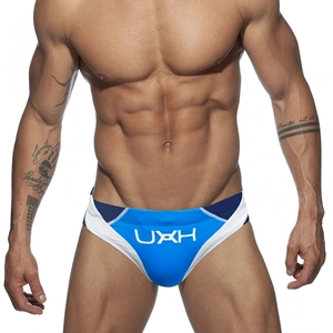 Detail of blue men's swim briefs showing color-block stitching and white UXH logo