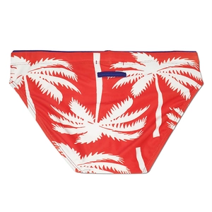 Rear view of red men's swim briefs with white palm tree prints and blue trim accents