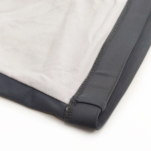 Close-up of flatlock stitching on dark gray swim trunks with stretch fabric edge