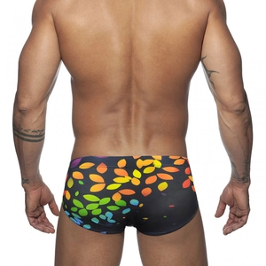 Men's low-waist swim trunks featuring vibrant colorful leaf print on a black base fabric