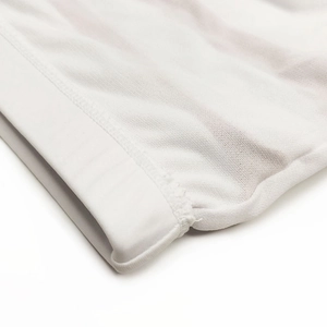 Macro detail of men's swimming trunks showing white textured fabric and flat stitching