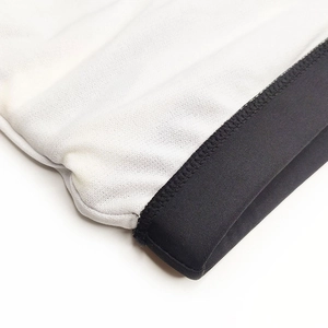 Detail of white mesh fabric with black elastic waistband stitching on men's swimwear