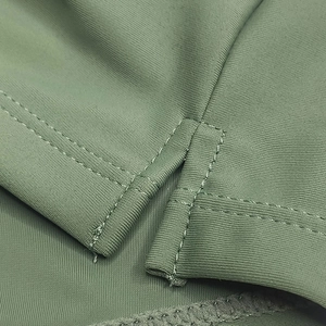 Detailed side slit on sage green swim trunks featuring reinforced double-stitched seams