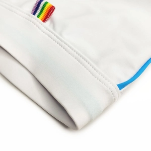 Macro detail of white swimwear fabric with rainbow label and blue piping edges