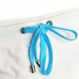 Close-up of swim trunks waist with bright blue drawstring and metallic aglets
