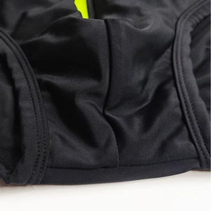 Close-up of ergonomic stitching on black mesh swim briefs with neon green detail