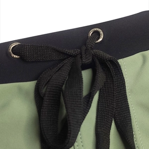 Detail of swimwear elastic waistband with drawstring and engraved metal eyelets