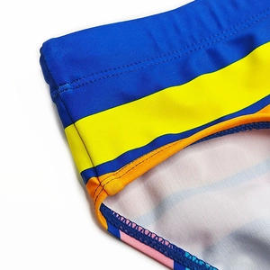 Detail shot of blue yellow orange striped men swimwear with double needle stitching