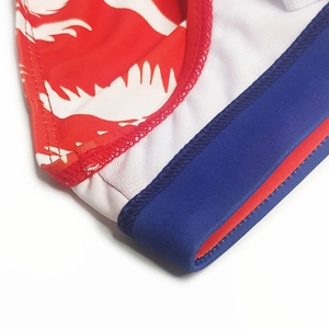 Detailed close-up of men's swim briefs featuring fire print fabric and breathable mesh lining