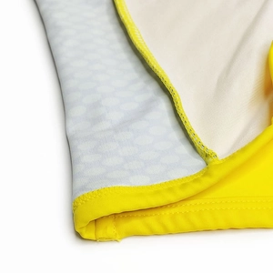 Close-up of vibrant yellow seam and grey polka dot pattern on men's quick-dry swim trunks