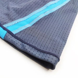 Macro detail of breathable mesh fabric and blue side stripes on men's swim trunks