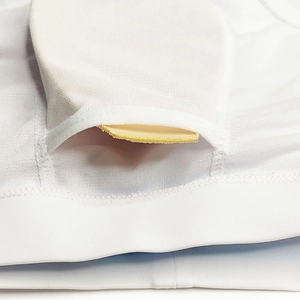 Macro view of the inner chest pad pocket and mesh fabric on a white sports vest