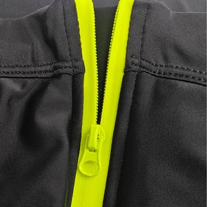 Close-up of functional neon green zipper and elastic mesh fabric on men's swimwear