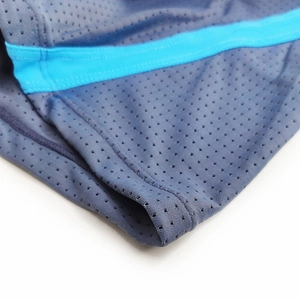 Macro detail of breathable mesh fabric and reinforced stitching on men's swim trunks