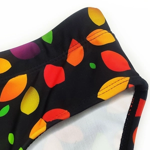 Close-up of colorful leaf pattern on black men's swim trunks with double-stitch detail