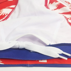 Close-up of men's quick-dry swim briefs showing white drawstring and floral texture detail