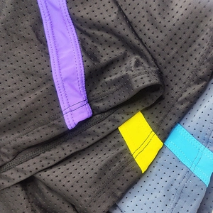 Detail of breathable mesh swim trunks with reinforced stitching and colored side stripes
