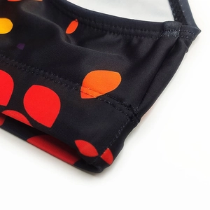 Close-up of black swim briefs with colorful polka dot prints and durable double stitching