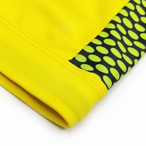Close-up of men's quick-dry swim trunks with yellow fabric and green polka dot side stitching