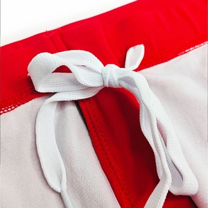 Detail of red men's swimwear featuring a sturdy white drawstring and precise stitching