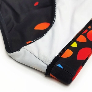 Detailed close-up of high-elastic swimwear fabric with colorful leaf print and stitching