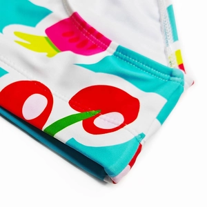 Détail du tissu extensible avec imprimé fruits pop art et couture plate sur le maillot