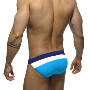 Rear view of men's low-rise swim briefs featuring navy, white, and sky blue patchwork design