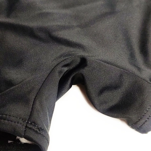 Macro shot of black swim trunks showing elastic knit fabric texture and seam detailing