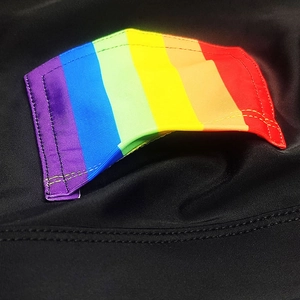 Macro detail of rainbow striped woven tape stitched on black elastic swimwear fabric