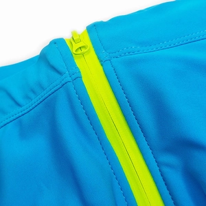 Detail of high-stretch sky blue swimwear featuring a vibrant neon yellow zipper closure