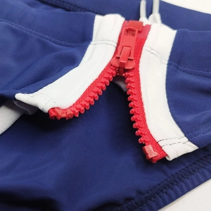 Détail du slip de bain homme avec fermeture éclair rouge et passepoil blanc contrastant
