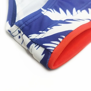 Detailed macro view of tropical palm print fabric and high-elastic red hem stitching