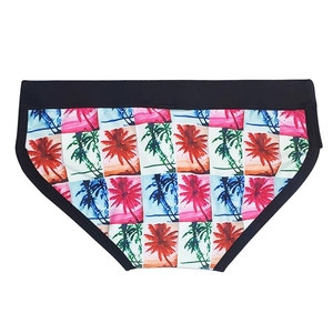 Dettaglio slip da nuoto uomo con stampa di palme e fascia elastica nera in vita