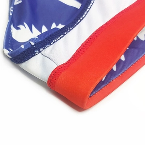Detailed macro view of high-density stitching on elastic swim trunks with palm prints