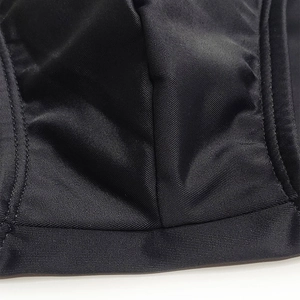 Macro shot of durable double-stitch seams on black quick-dry stretch swimming trunks