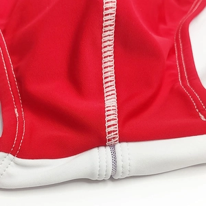 Close-up of white double stitching on red men's swimwear with high elasticity