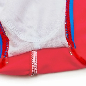 Detailed macro view of red swim briefs featuring blue elastic trim and white honeycomb stitching