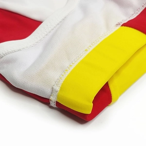 Close-up of contrast stitching and tricolor fabric panels on men's athletic swimwear