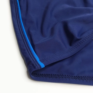 Detailed close-up showing reinforced double-stitching and navy fabric on swim trunks