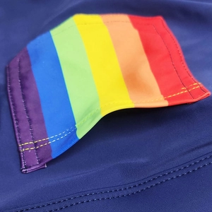 Close-up of rainbow striped badge on navy blue swim shorts with professional stitching