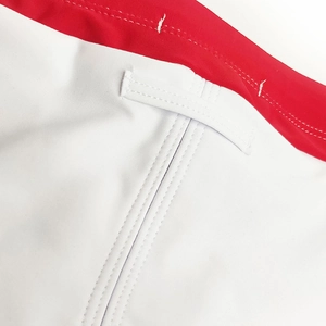 Detail view of reinforced stitching and white strap on sports swimwear fabric