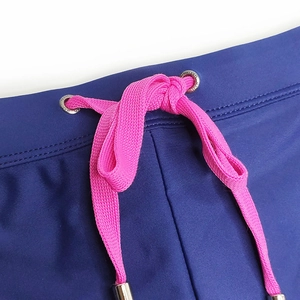 Détail du short de bain bleu marine avec cordon rose et œillets métalliques de qualité