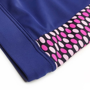 Détail macro du maillot de bain homme séchage rapide avec tissu élastique et pois roses