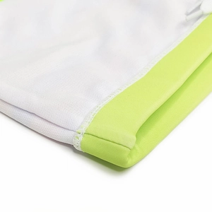 Détail macro du tissu en maille respirante avec bordure contrastée vert fluo et couture
